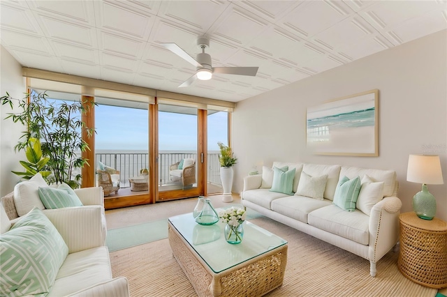 carpeted living room featuring a water view and ceiling fan