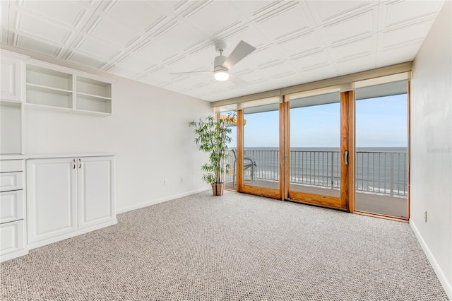 5201 S Atlantic Ave Unit 809A, New Smyrna Beach, FL 32169 - spare room featuring a water view, baseboards, ceiling fan, and carpet flooring