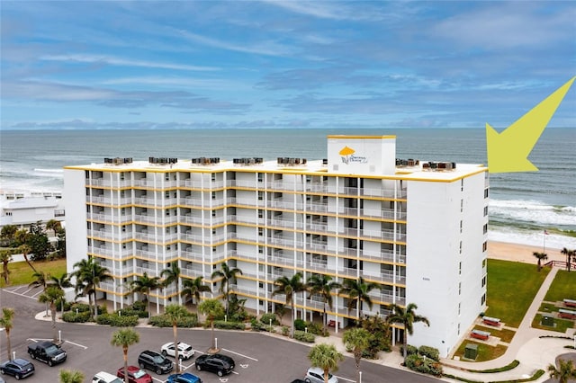 5201 S Atlantic Ave Unit 809A, New Smyrna Beach, FL 32169 - view of apartment building / complex featuring view of water and beach and uncovered parking