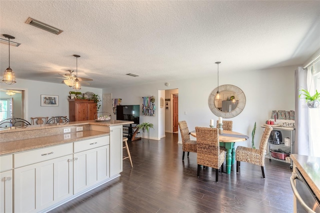 kitchen with white cabinets, decorative light fixtures, ceiling fan, and dark hardwood / wood-style flooring