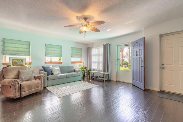 living room featuring dark hardwood / wood-style floors, a healthy amount of sunlight, a textured ceiling, and ceiling fan