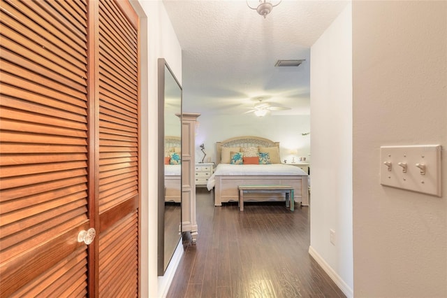 bedroom featuring a textured ceiling, ceiling fan, and dark wood-type flooring