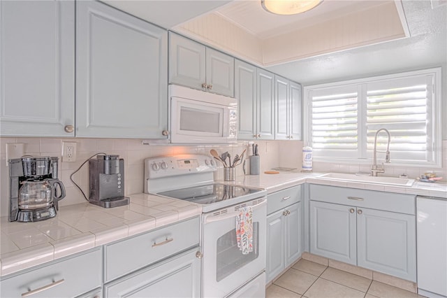4017 Saxon Dr, New Smyrna Beach, FL 32169 - kitchen featuring white appliances, light countertops, tasteful backsplash, and light tile patterned flooring