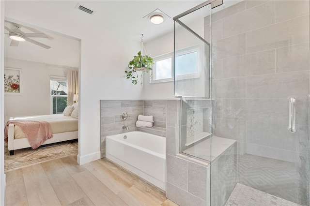 bathroom featuring ceiling fan, wood-type flooring, and independent shower and bath