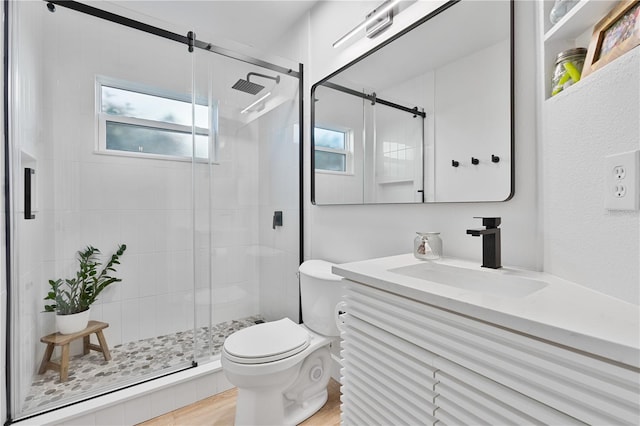 bathroom with a shower with shower door, toilet, wood-type flooring, and vanity