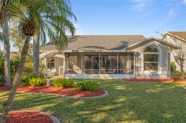 rear view of property featuring a lawn and a sunroom