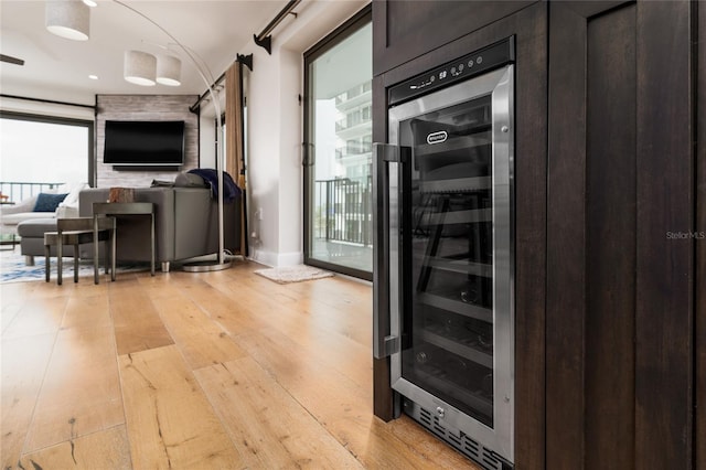 interior space with a healthy amount of sunlight, light wood-type flooring, and wine cooler