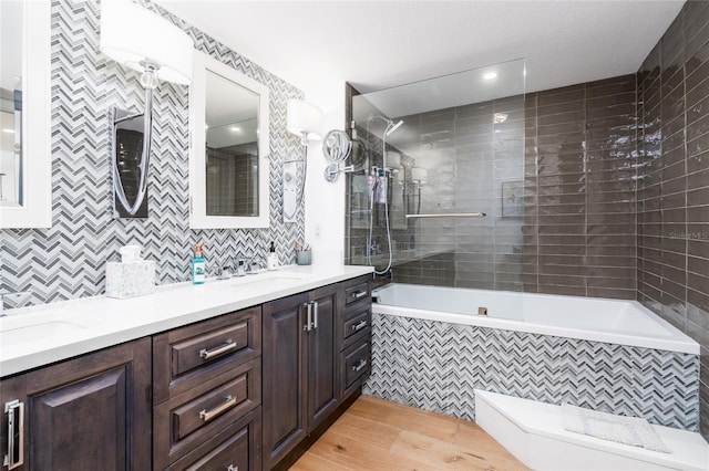 full bathroom featuring vanity, tiled shower / bath combo, toilet, tile walls, and wood-type flooring