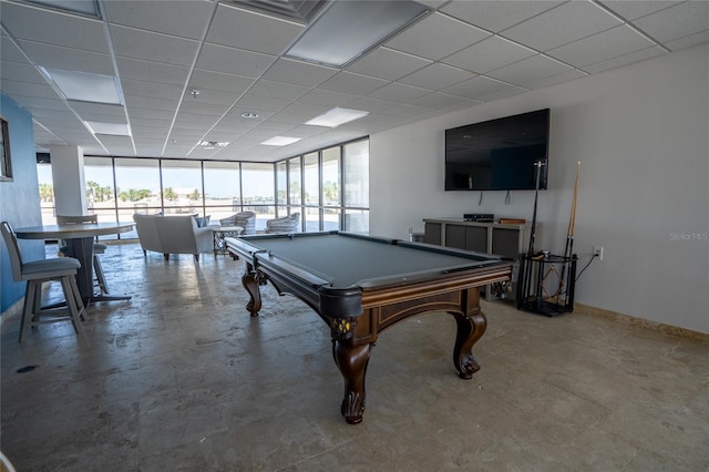 playroom featuring a drop ceiling, a wealth of natural light, concrete floors, and billiards