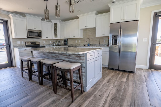 kitchen with white cabinets, a kitchen island, and stainless steel appliances