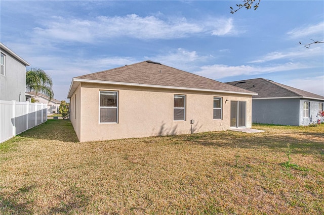 rear view of property featuring a yard