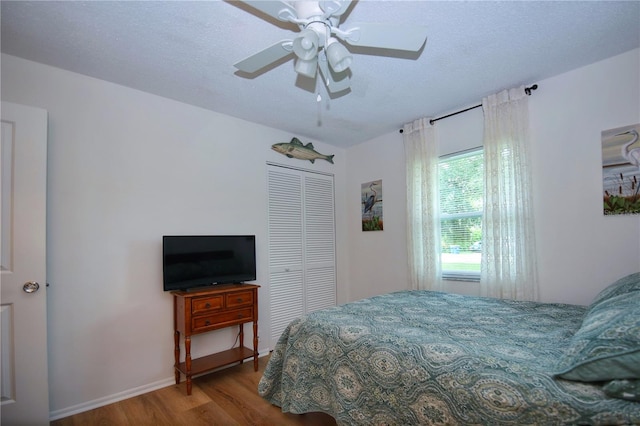 bedroom with ceiling fan, a closet, a textured ceiling, and hardwood / wood-style flooring