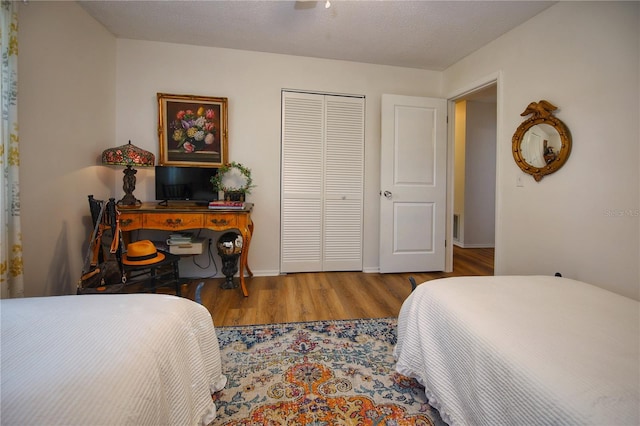 bedroom featuring a closet, wood-type flooring, and a textured ceiling