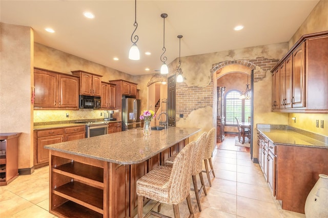 kitchen featuring stone counters, a kitchen breakfast bar, hanging light fixtures, light tile patterned flooring, and stainless steel appliances