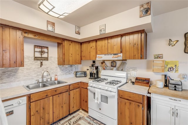 kitchen with tasteful backsplash, white appliances, extractor fan, sink, and light tile patterned floors