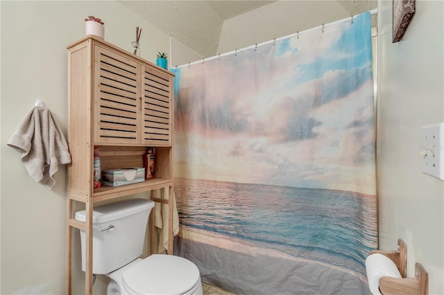 bathroom featuring a shower with shower curtain, a textured ceiling, and toilet