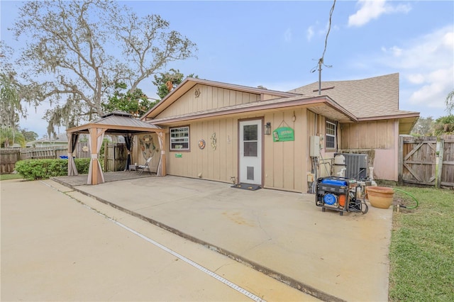 back of property with a gazebo and a patio