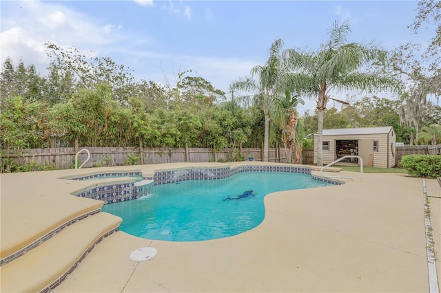 view of pool with a patio area, an in ground hot tub, and an outbuilding