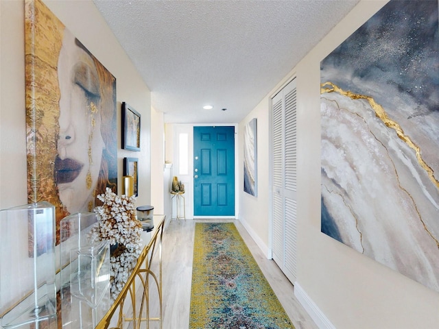 hall featuring hardwood / wood-style floors and a textured ceiling