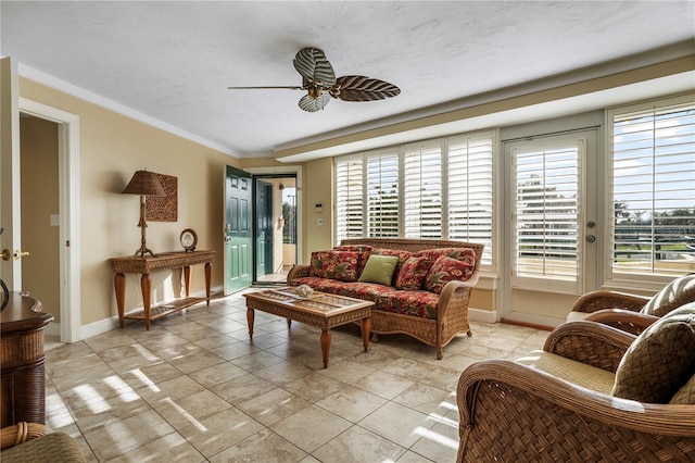 living room with ornamental molding and ceiling fan