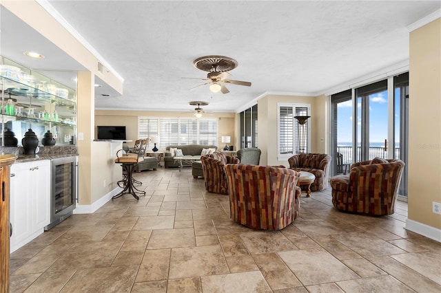 living room with ornamental molding, indoor bar, wine cooler, and ceiling fan