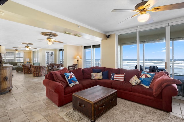 living room with crown molding, a wall of windows, ceiling fan, and a water view