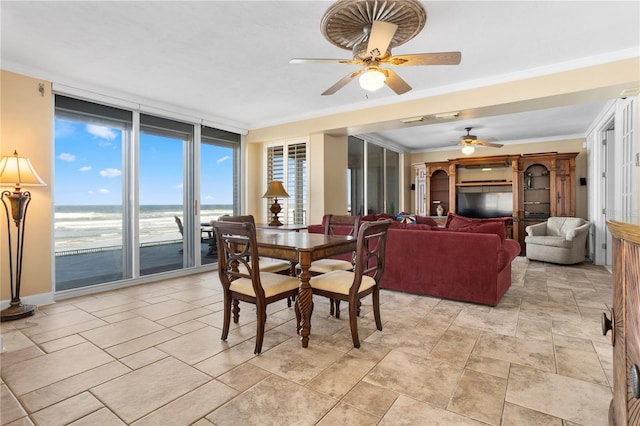 dining space with crown molding, floor to ceiling windows, ceiling fan, and a water view