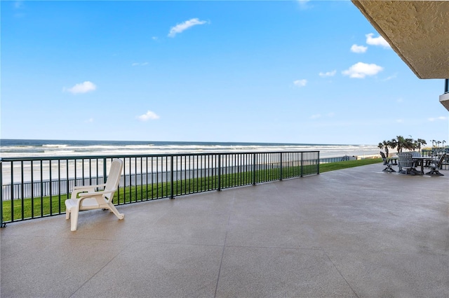 view of patio / terrace featuring a water view and a view of the beach