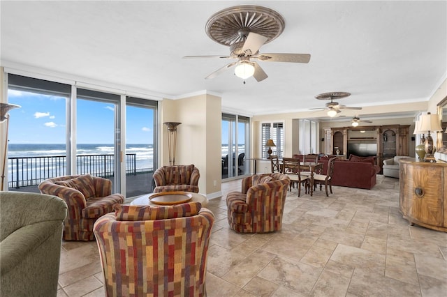 living room with ornamental molding, expansive windows, ceiling fan, and a water view