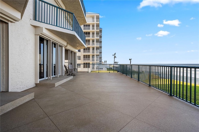 view of patio / terrace with a balcony and a water view