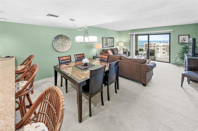 dining space featuring a notable chandelier and light carpet