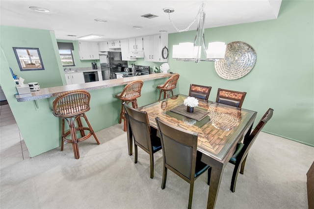 carpeted dining room with sink