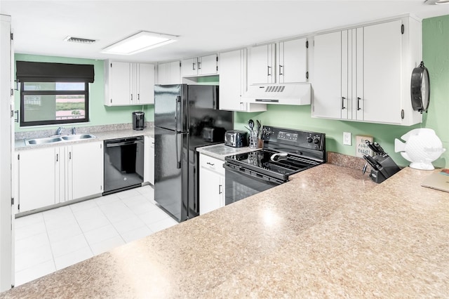 kitchen with light tile patterned floors, sink, white cabinetry, and black appliances