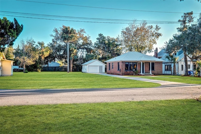 view of front of house featuring an outbuilding, a front yard, and a garage