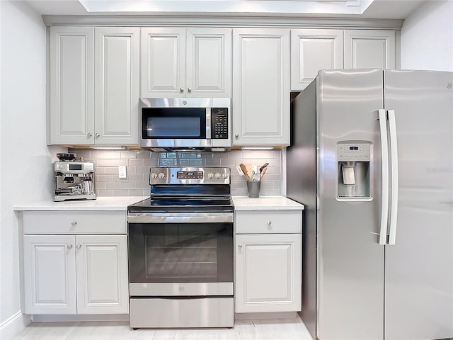 kitchen with white cabinetry, decorative backsplash, and stainless steel appliances