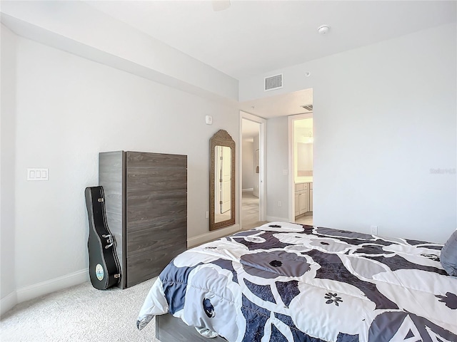 carpeted bedroom featuring ensuite bath