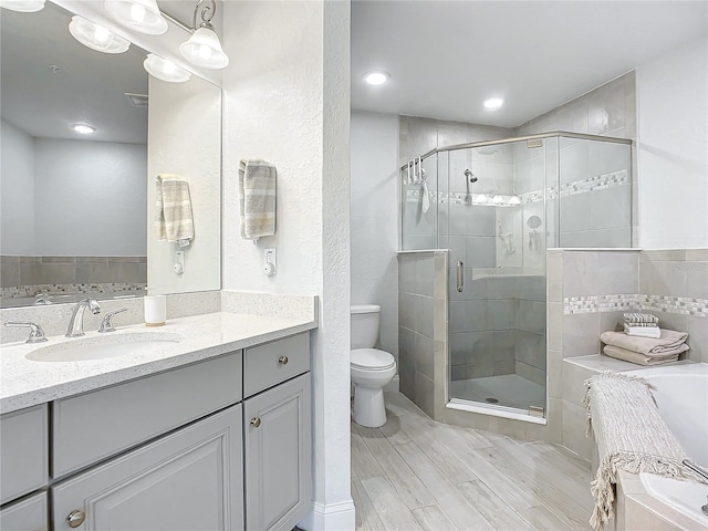 full bathroom featuring vanity, independent shower and bath, and toilet