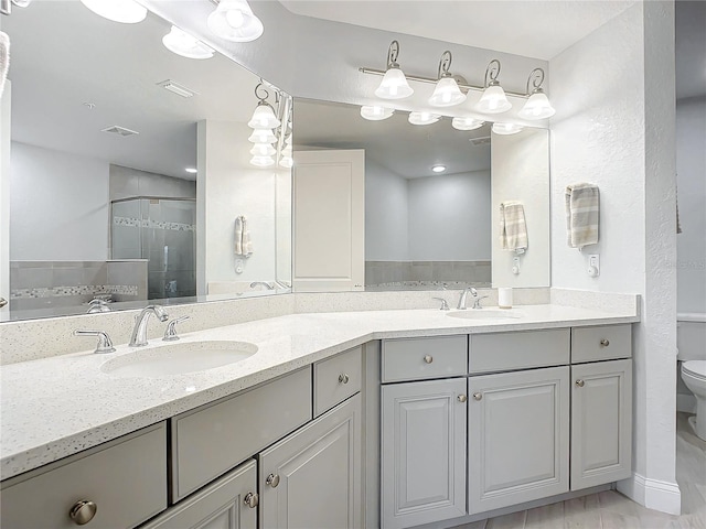 bathroom featuring an enclosed shower, vanity, and toilet