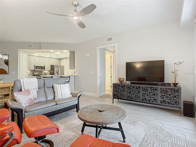 living room with light hardwood / wood-style floors and ceiling fan