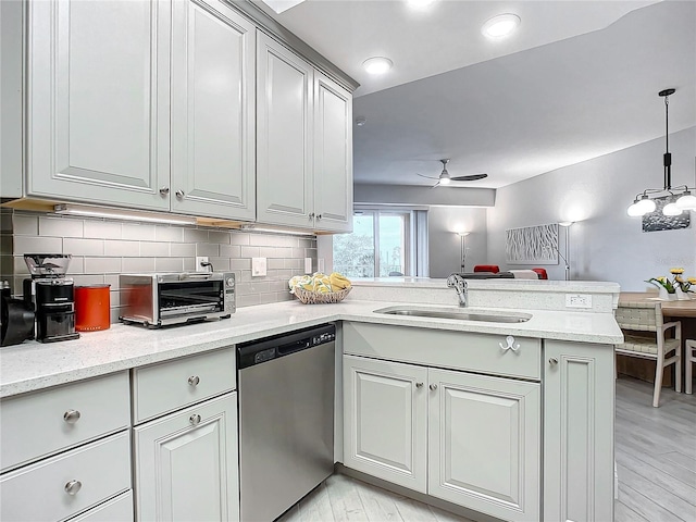 kitchen featuring sink, ceiling fan, tasteful backsplash, stainless steel dishwasher, and kitchen peninsula