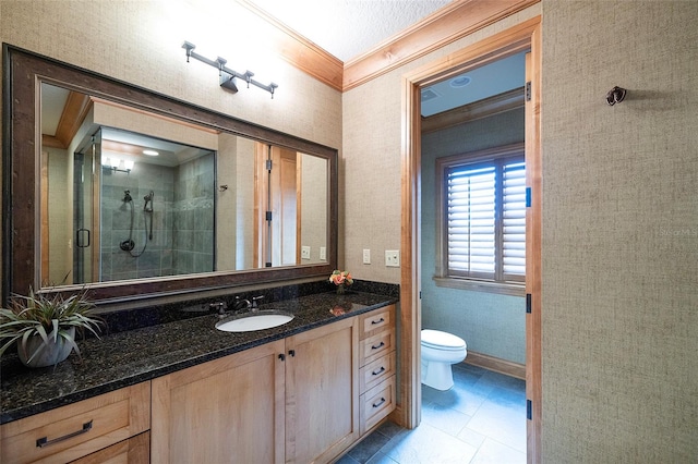 bathroom featuring vanity, crown molding, toilet, a textured ceiling, and a shower with shower door