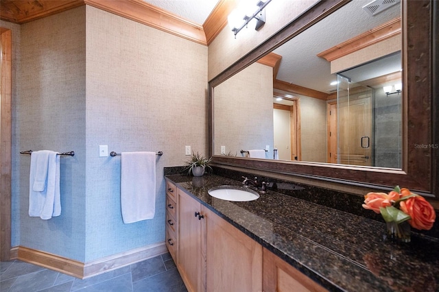 bathroom with tile patterned floors, a textured ceiling, vanity, a shower with door, and crown molding