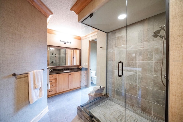 bathroom with tile patterned floors, a textured ceiling, toilet, vanity, and a shower with shower door