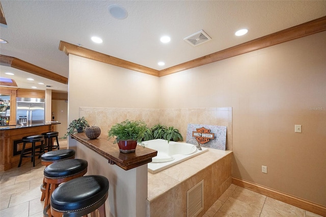 interior space featuring tile patterned floors, a relaxing tiled tub, and a textured ceiling