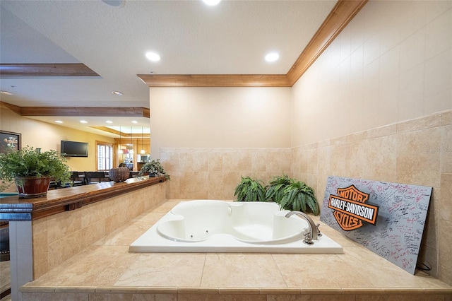 bathroom with a textured ceiling, tiled bath, tile walls, and crown molding