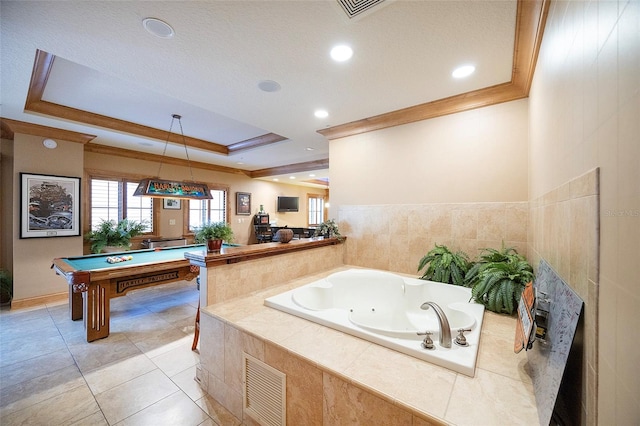 bathroom with a raised ceiling, tile patterned flooring, a relaxing tiled tub, and billiards