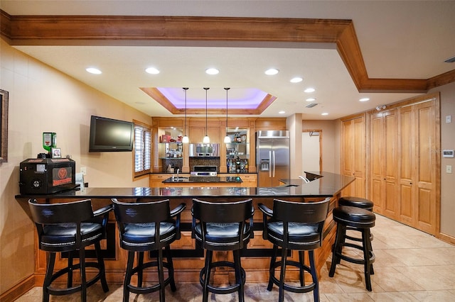 bar featuring ornamental molding, appliances with stainless steel finishes, a tray ceiling, decorative light fixtures, and light tile patterned flooring