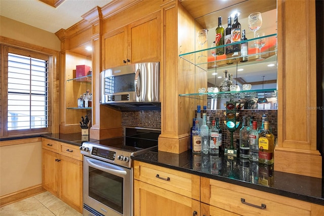 kitchen featuring light tile patterned floors, stainless steel appliances, and a textured ceiling