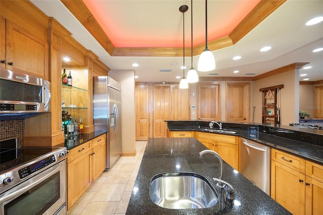 kitchen with stainless steel appliances, a raised ceiling, sink, pendant lighting, and dark stone countertops