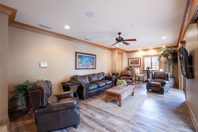 living room featuring hardwood / wood-style flooring, ceiling fan, and ornamental molding